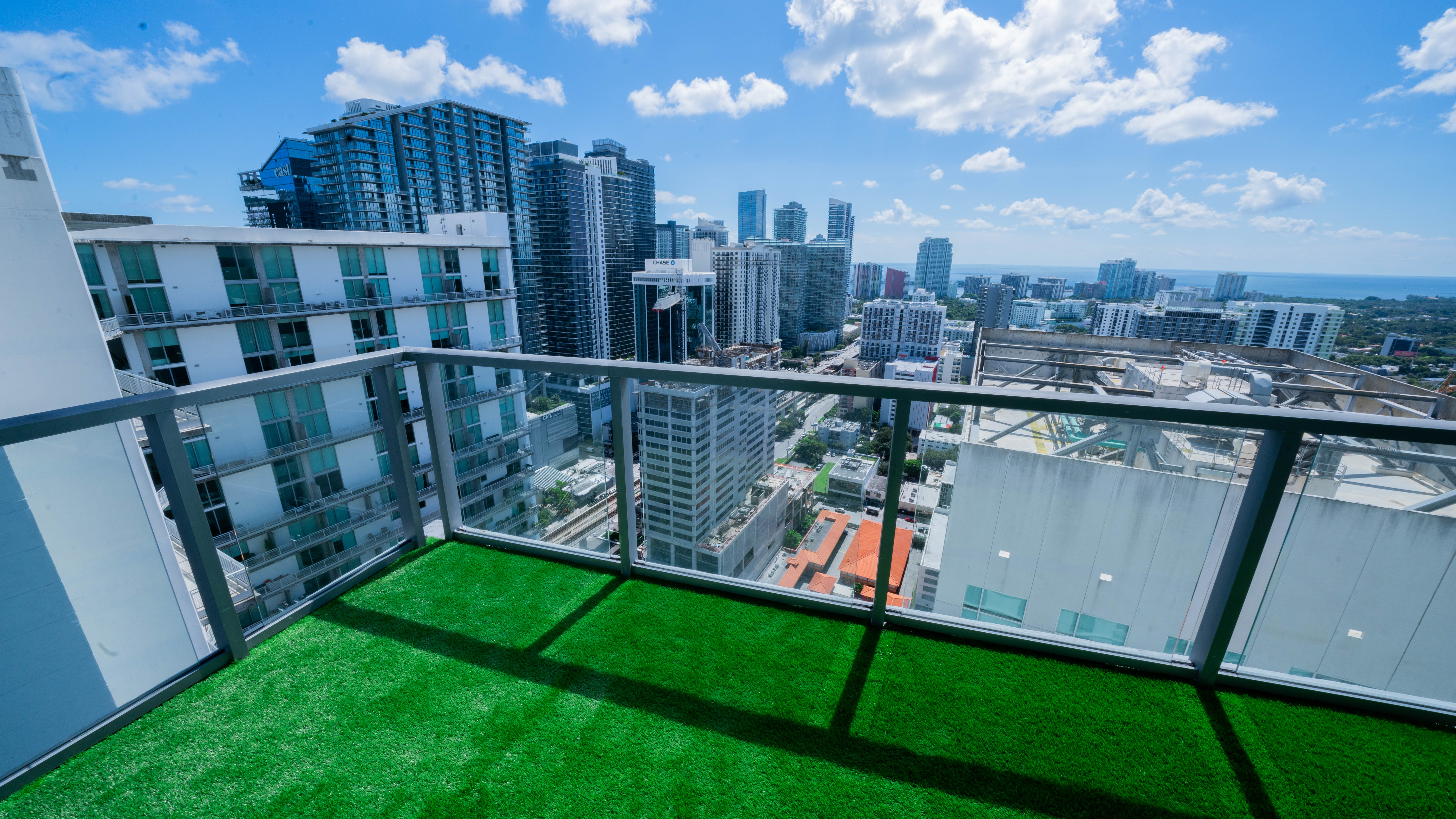 Balcony after turf installation — green turf with clean edges around railing