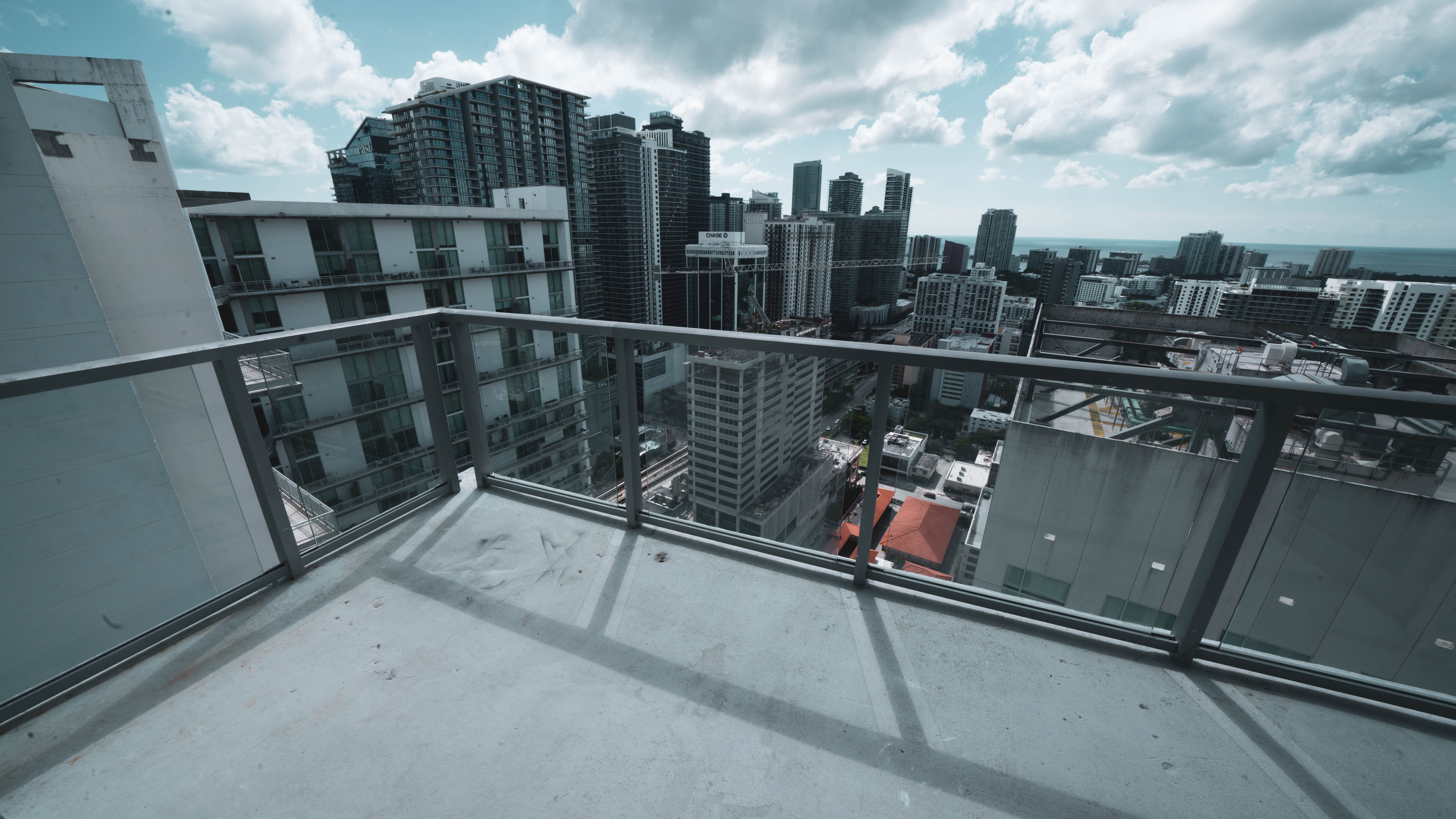 Balcony before turf — bare concrete with tape measure laid out