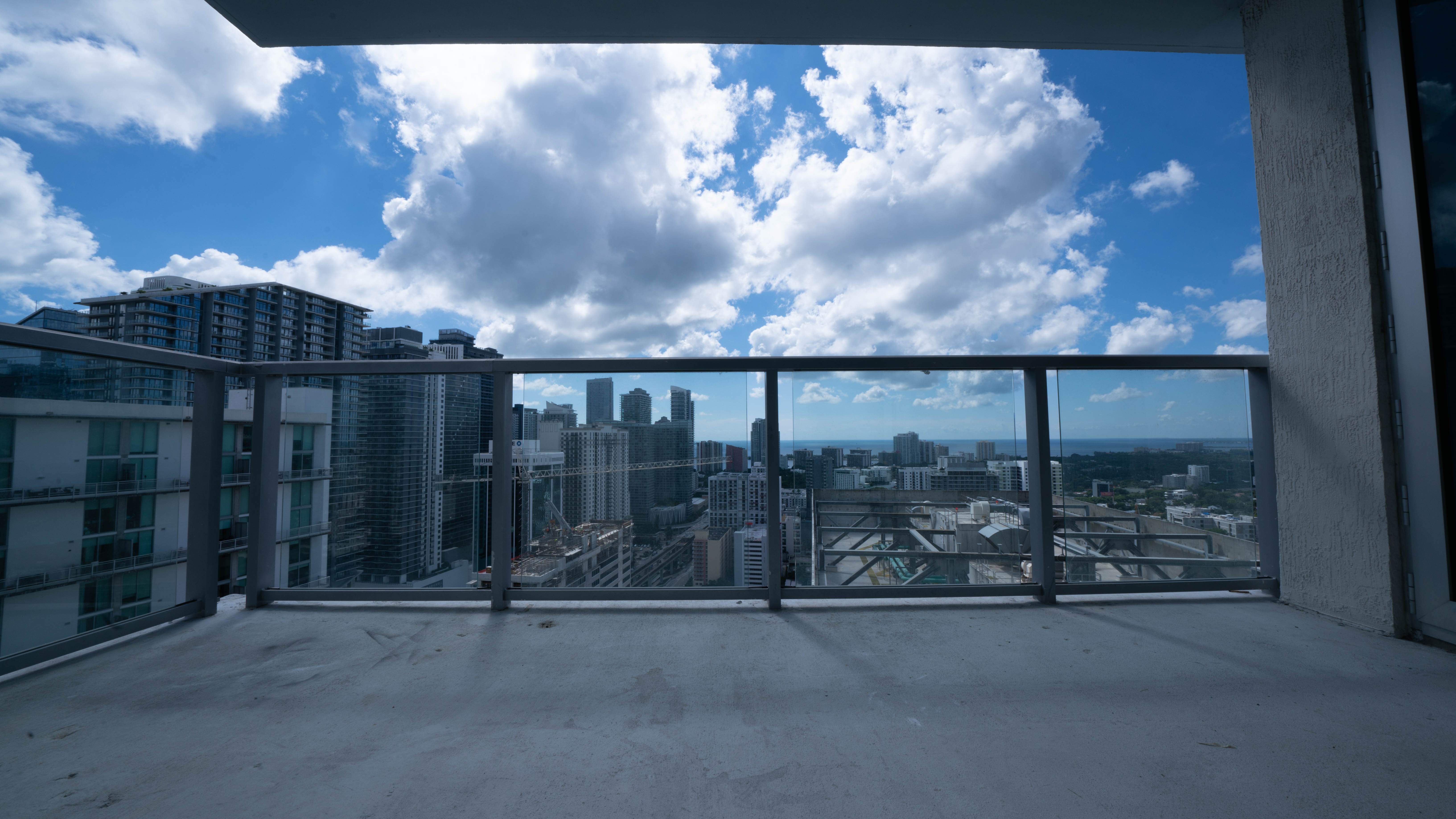 Condo balcony before turf — bare surface awaiting HOA approval and installation